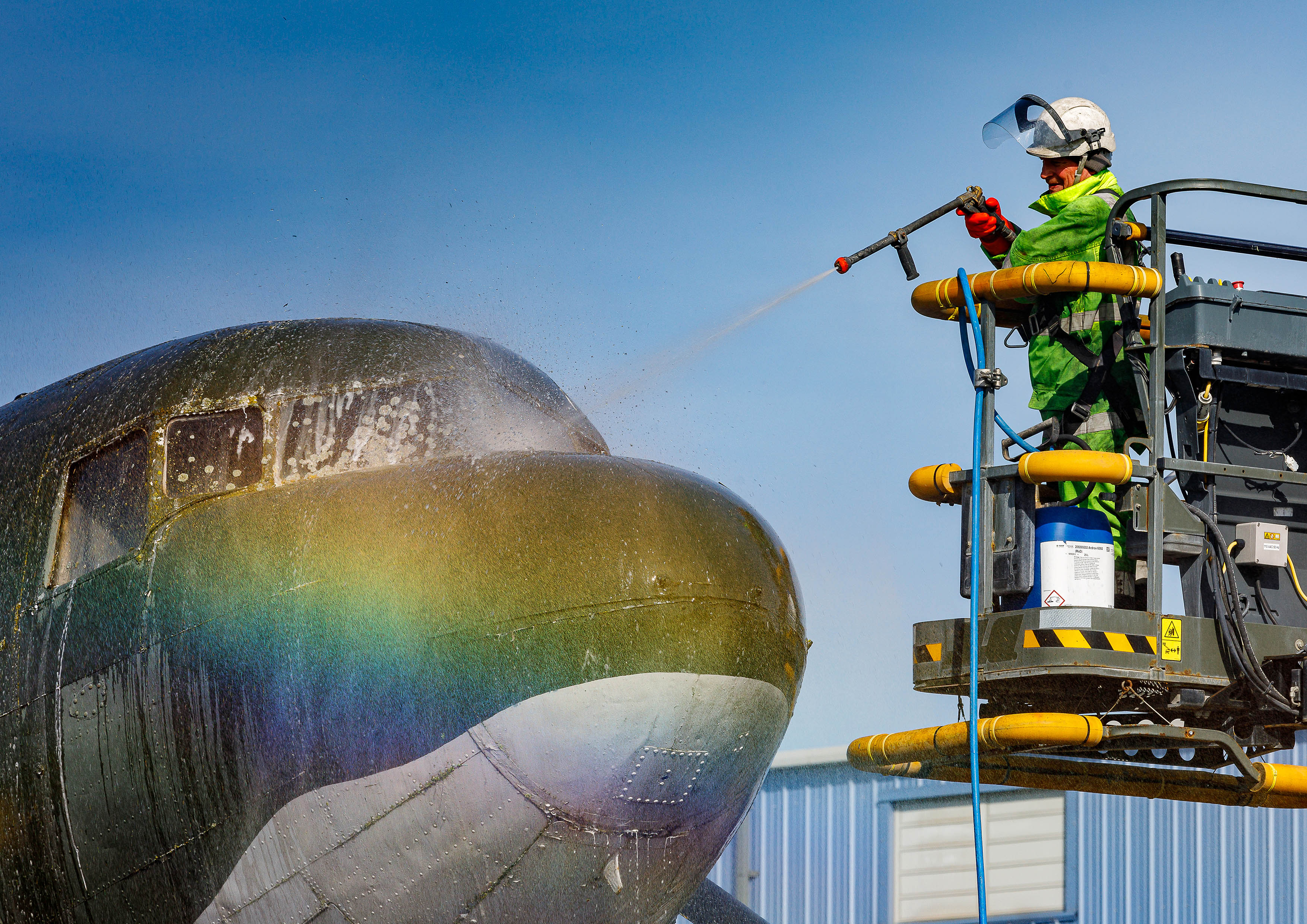 Photo: A member of the Serco Aircraft Wash Team pressure washing the area outside of the flight deck